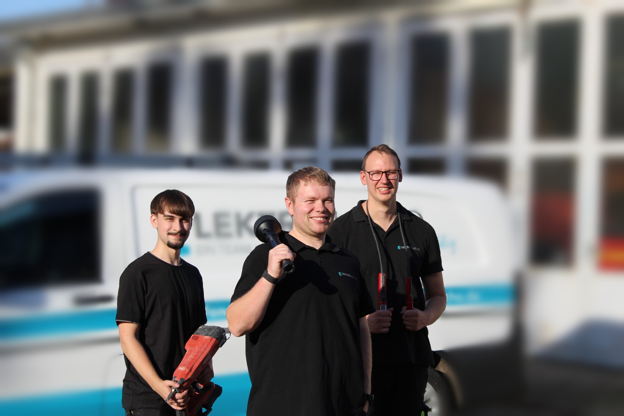 Marius, Christian und Lennart vor dem Firmenwagen